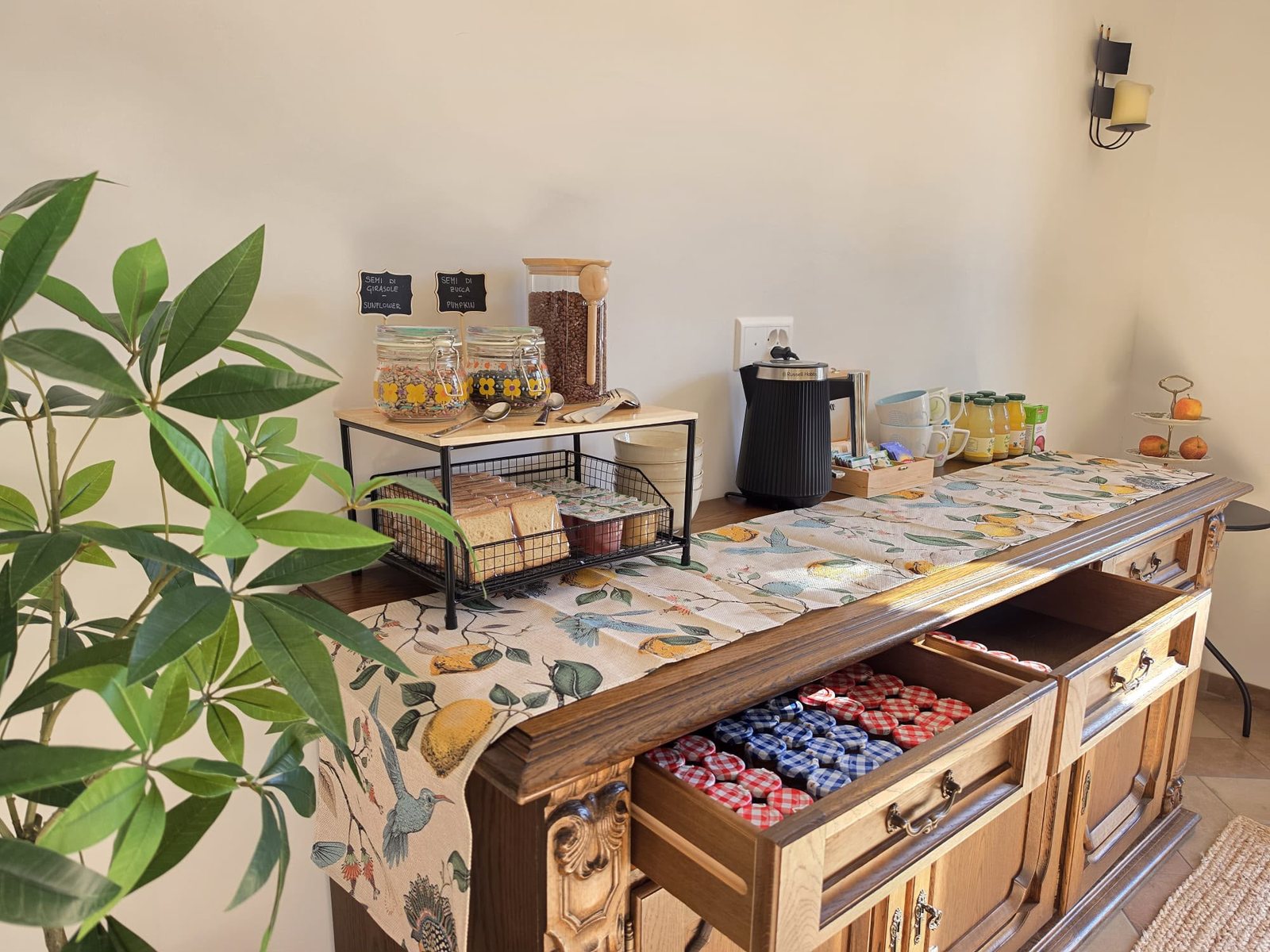 La credenza della colazione con i barattoli, i cereali e i cassetti delle confetture
