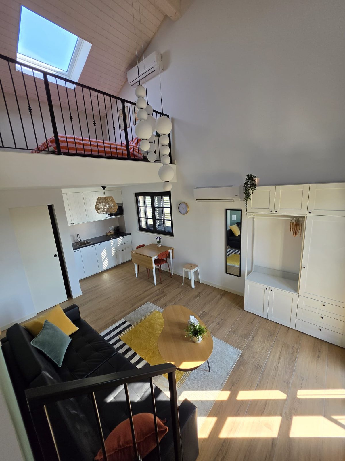 L’appartamento Rosmarino visto dall’ingresso: soppalco, cucina e zona giorno