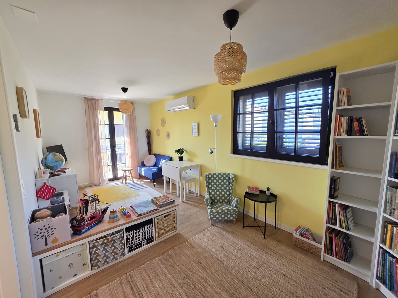 Il locale svago del B&B Airone: libreria, angolo per i bambini, poltrona e parete gialla